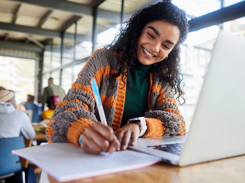 girl writing out a math problem at her desk