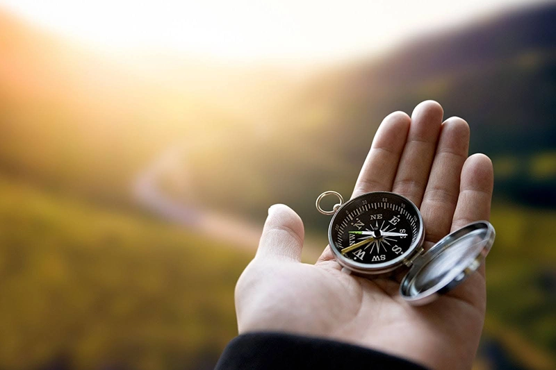 a hand holding a compass