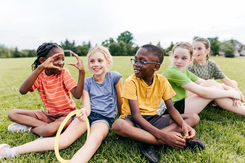 group of middle school students sitting in a group on the playground